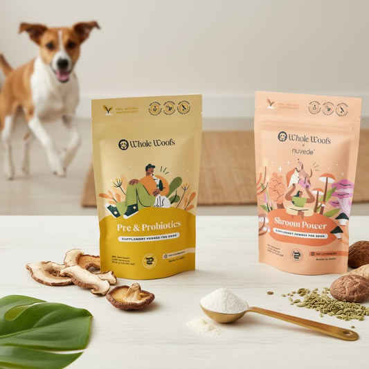 Two Whole Woofs pet supplement packages on a table with ingredients and a dog in the background.